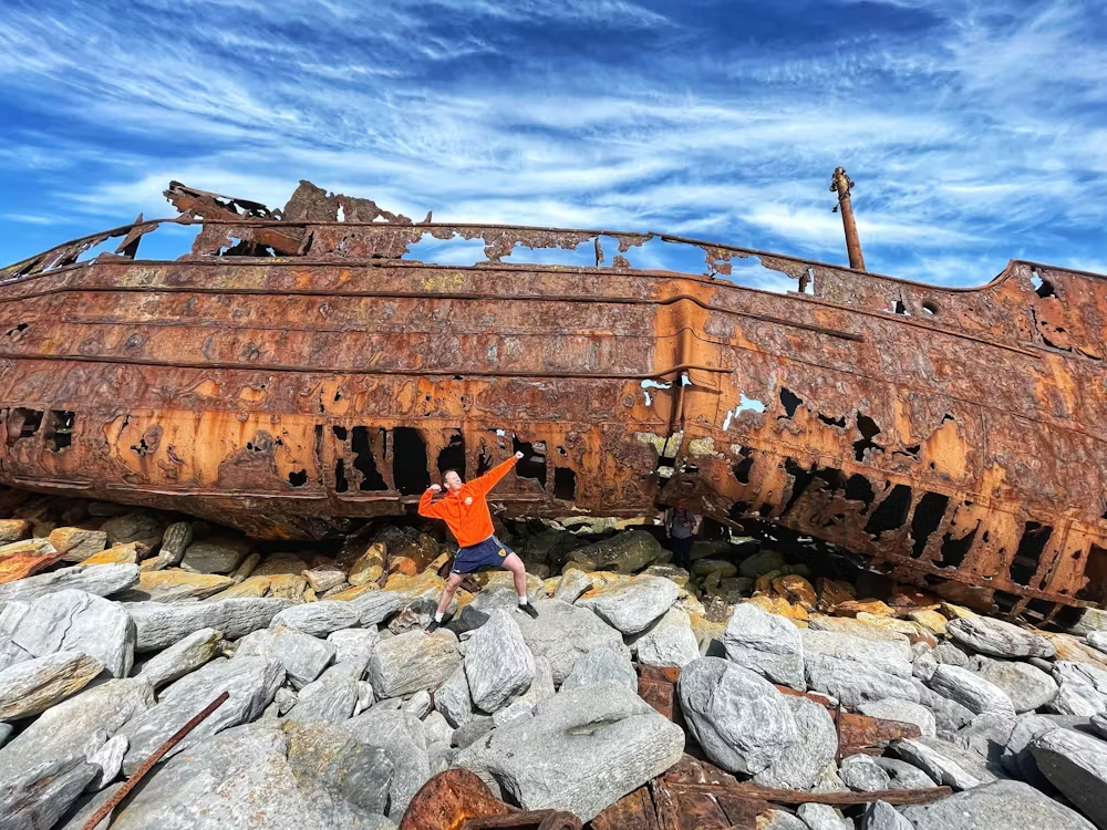 Ollie posing in front of a wrecked boat