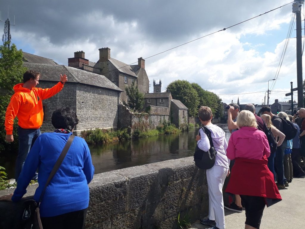 Tour guide showing group of tourists a landmark