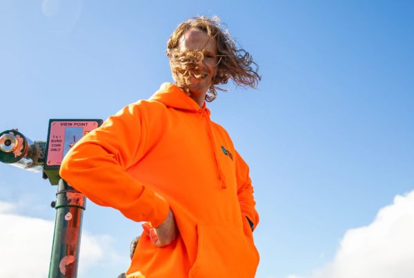 Ollie smiles by viewpoint telescope with blue sky background.